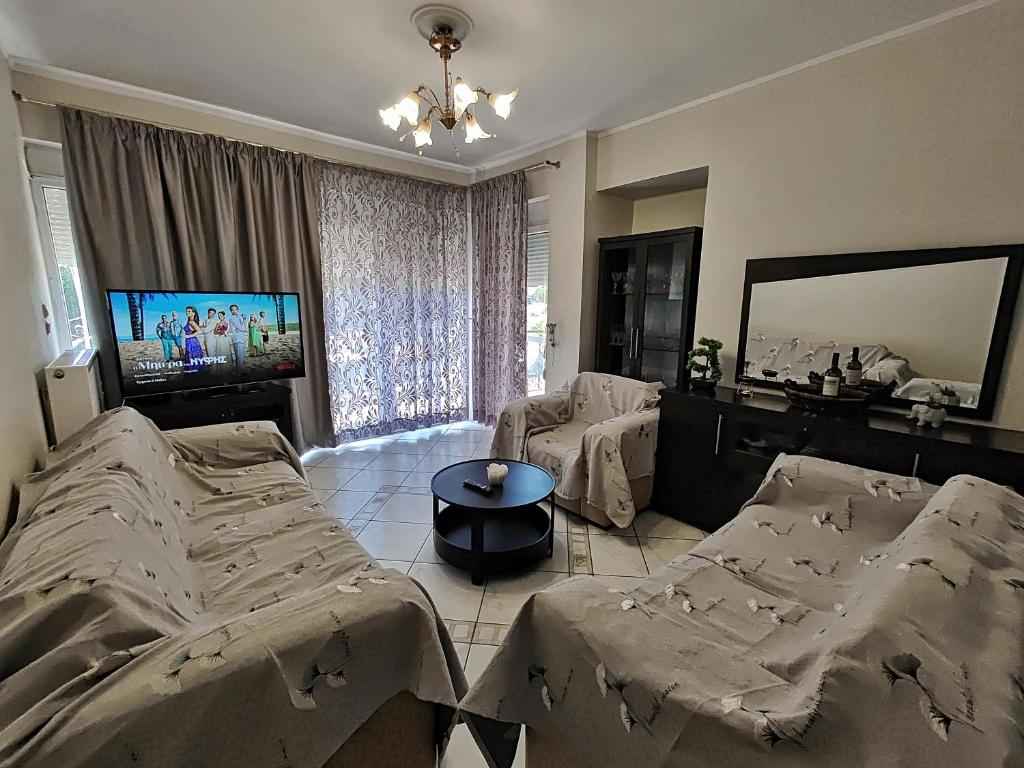 a bedroom with two beds and a flat screen tv at Ioannina Urban Oasis with Jacuzzi in Katsikás