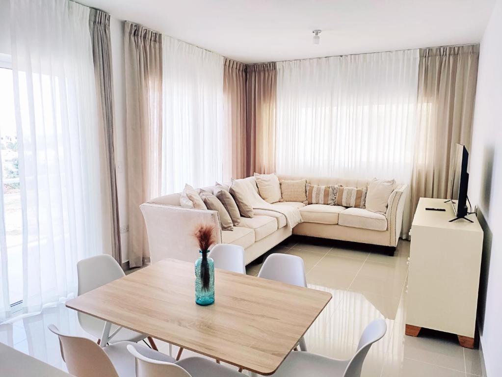 uma sala de estar com um sofá, uma mesa e cadeiras em Confortable Apartamento con Piscina en Cabrera em Cabrera
