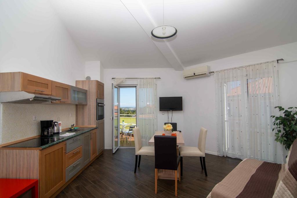 eine Küche und ein Esszimmer mit einem Tisch und einer Uhr an der Decke in der Unterkunft Cape Kamenjak Apartments in Premantura in Premantura