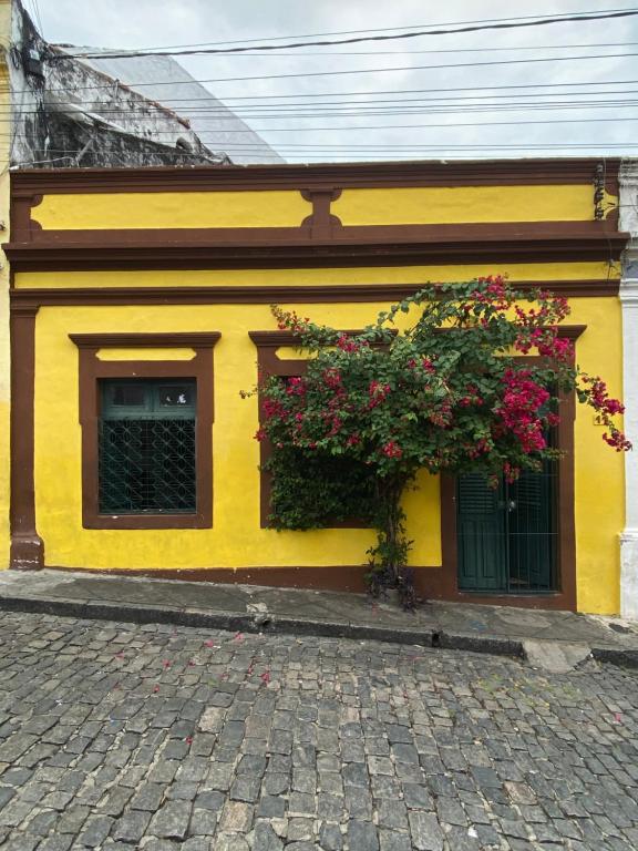 Casa de Olinda في أوليندا: مبنى اصفر وعليه ورد