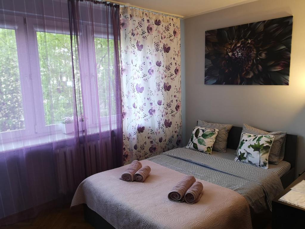 1 dormitorio con 2 camas y zapatillas en Przytulny Apartament w ścisłym Centrum, en Varsovia