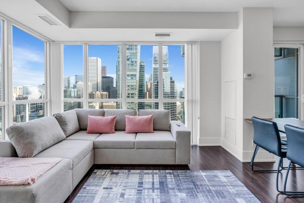 a living room with a couch and a large window at Modern Downtown Suites in Toronto