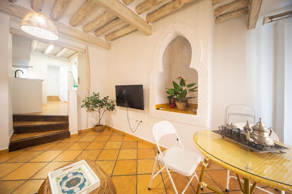 sala de estar con mesa y TV en Apartamentos Indalo a los pies del Albaicín, en Granada