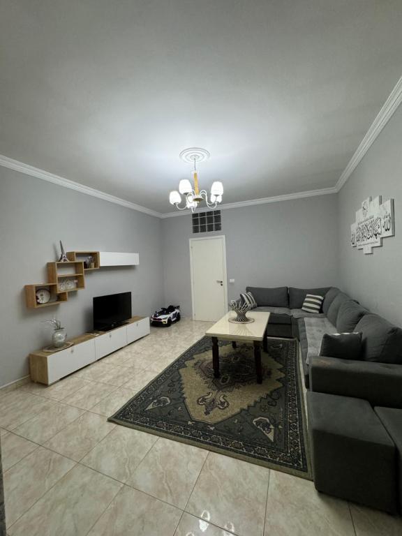 uma sala de estar com um sofá e uma mesa em SN Apartment city center em Shkodër