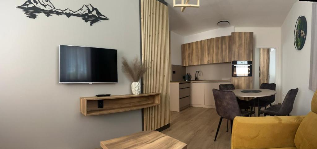 a living room with a tv on a wall at Apartman Valnela in Veľká Lomnica