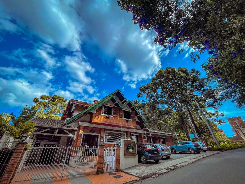 a house with cars parked in front of it at Pousada Atalaia Capivari in Campos do Jordão