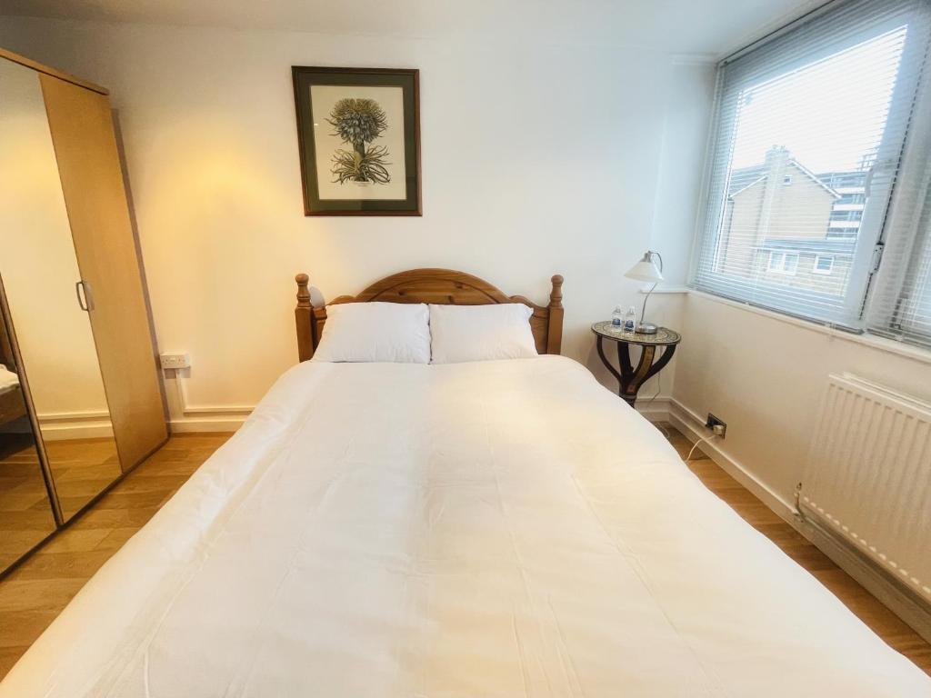 duże białe łóżko w pokoju z oknem w obiekcie Newly Renovated 2BR Apartment in the heart of London w Londynie