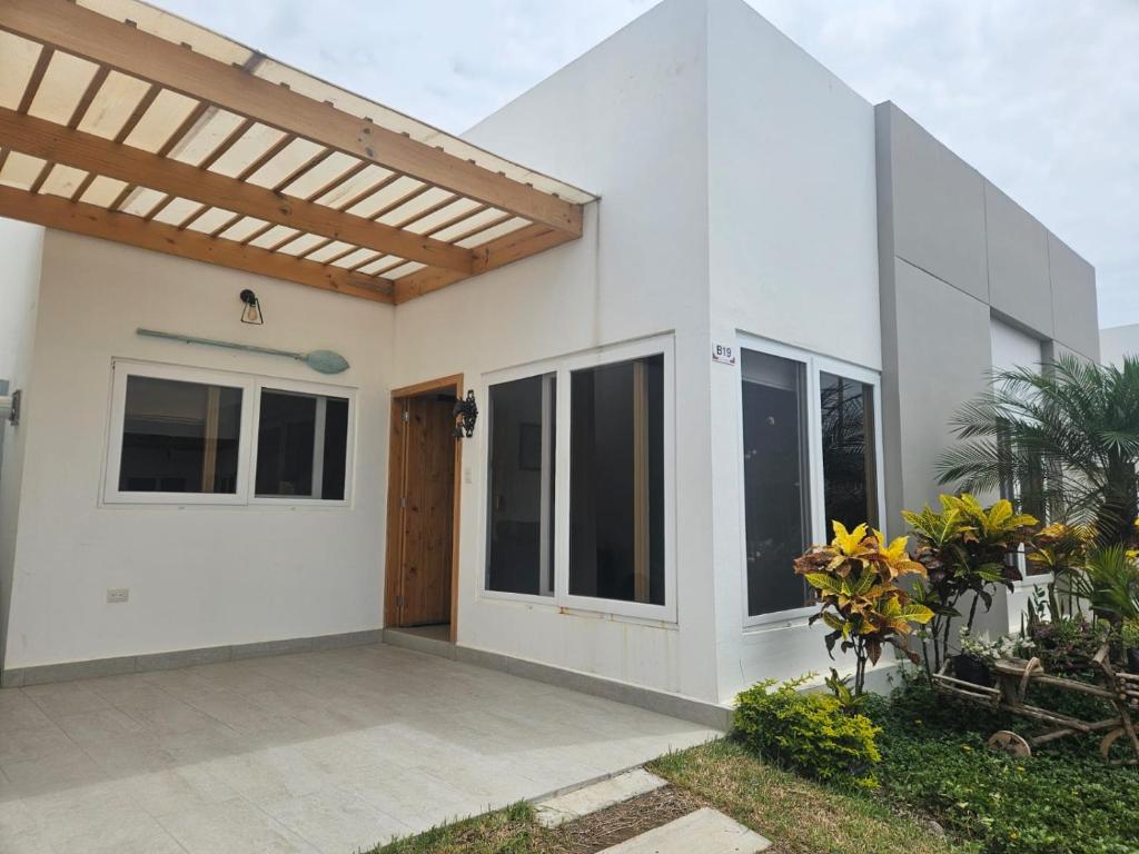 ein weißes Haus mit Markise und einer Terrasse in der Unterkunft Villa Country Club Salinas in Salinas