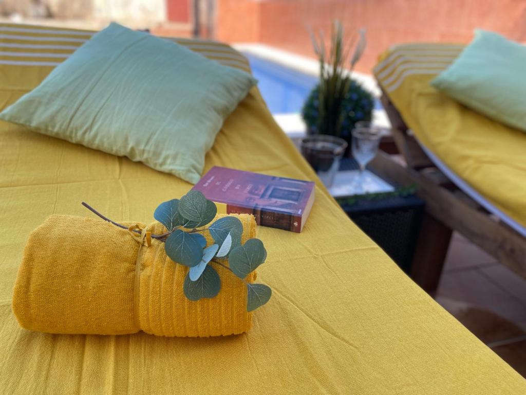 a yellow bed with a napkin and a box on it at Hevres El Capricho in Málaga