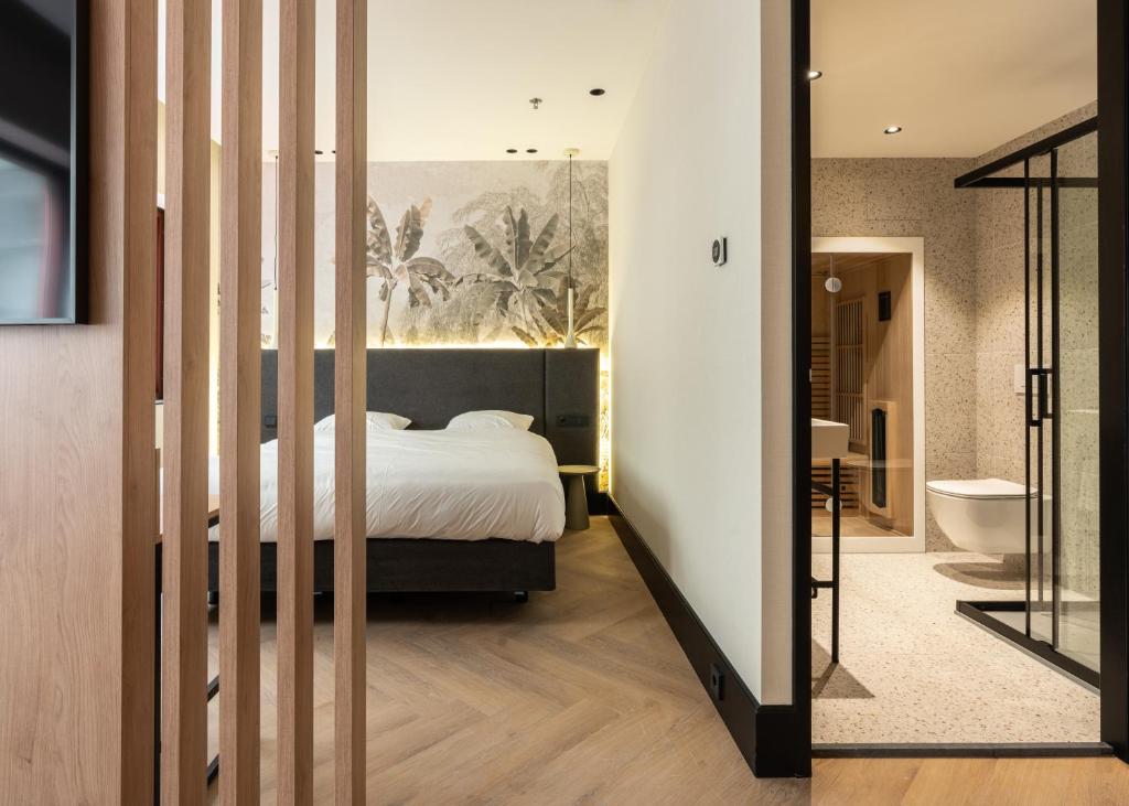 a bedroom with a large bed and a bathroom at MyHotel Meppel in Meppel