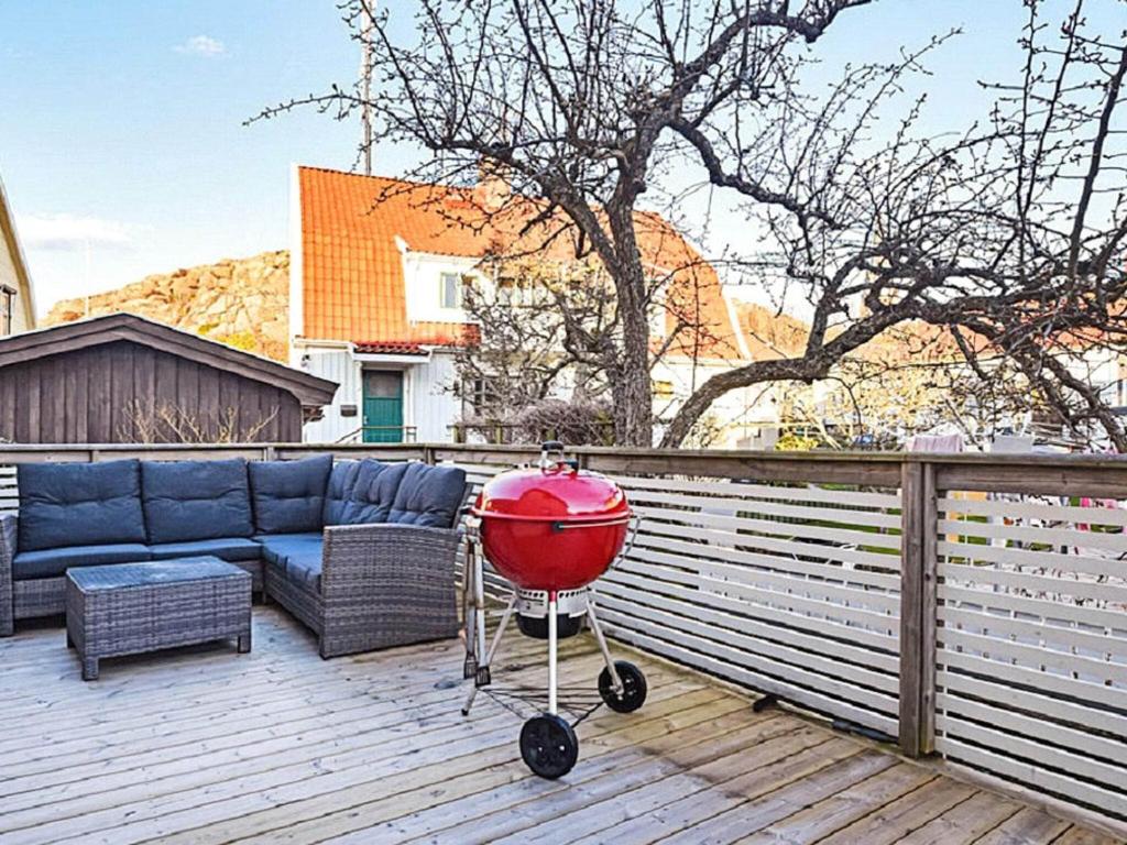 a red grill on a deck with a couch at Holiday home LYSEKIL XXXII in Lysekil