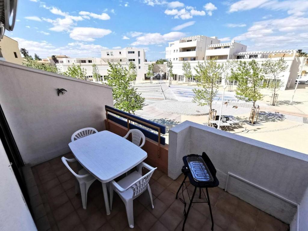 - un petit balcon avec une table et des chaises dans l'établissement Résidence Les Arenes - STUDIO 4 PERSONNES 4 couchages PORT LEUCATE MAE-7051, à Leucate