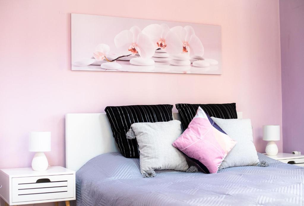 ブルガスにあるStudio Violetのベッドルーム1室(ピンクと白の枕が備わるベッド1台付)