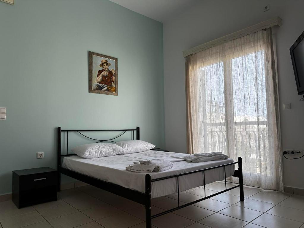 a bedroom with a bed and a large window at Captain's Lodge in Ermoupoli