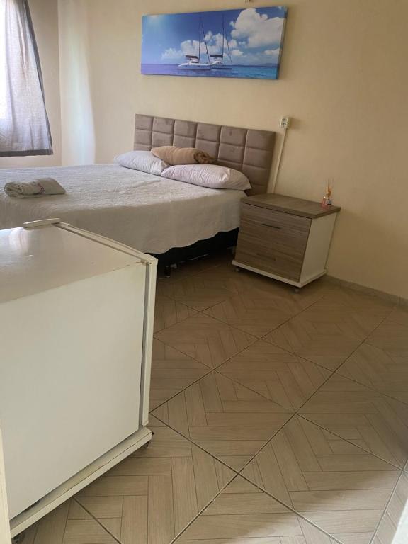 Schlafzimmer mit einem Bett und Holzboden in der Unterkunft apartamento no centro in Canindé