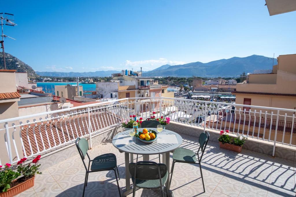 a table with a bowl of fruit on a balcony at Mondello SunSea House in Mondello