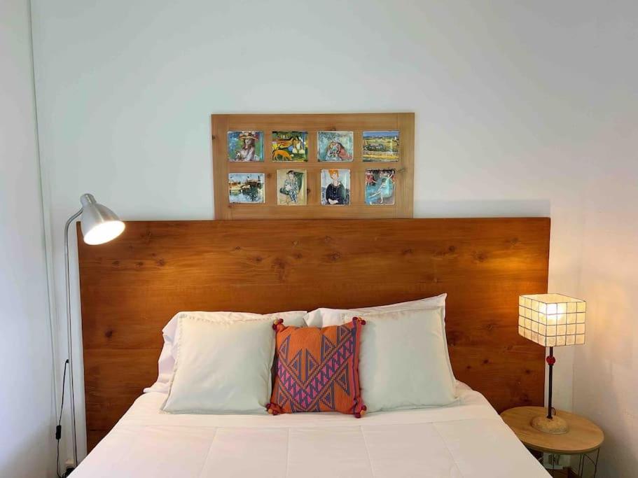 a bedroom with a white bed with a wooden headboard at Casa do Cacto - 1 Bedroom Cosy Flat in Madalena