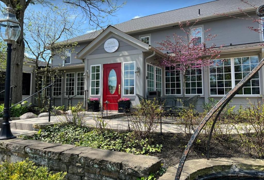 una casa con una puerta roja y un reloj en Inn of Chagrin en Chagrin Falls