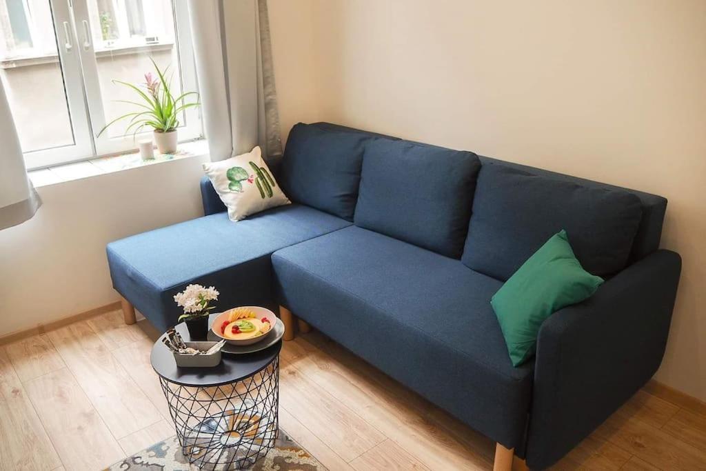 um sofá azul numa sala de estar com uma mesa em Old Town em Cracóvia