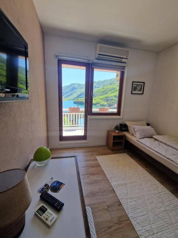- un salon avec un lit et une table dans l'établissement Visit Drežnica, à Mostar