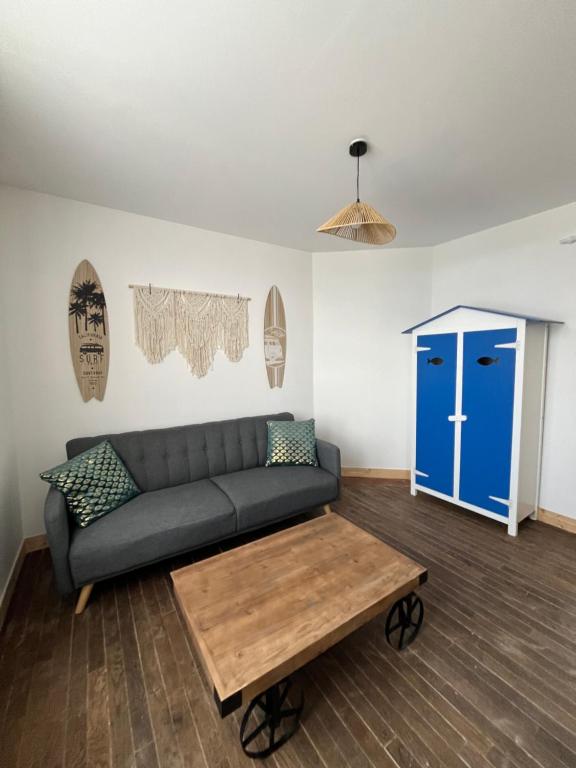 - un salon avec un canapé et une porte bleue dans l'établissement TY GWEN Appart1, à Châteaulin