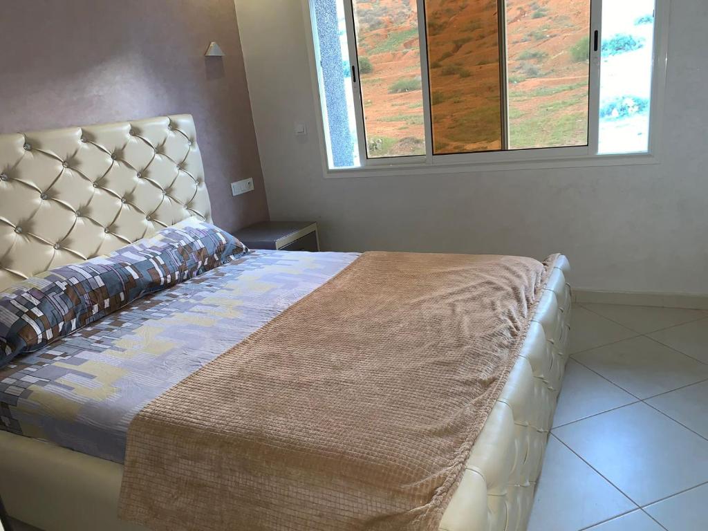 een slaapkamer met een groot bed met een groot hoofdeinde bij Apartamentos Palace Rif Al Hoceima in Al Hoceïma