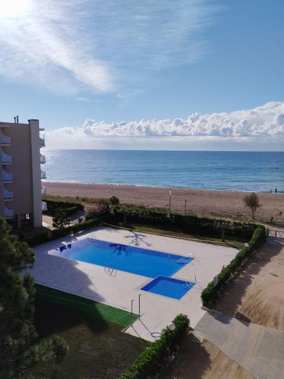 an overhead view of a swimming pool next to the beach at Apartamento Terraza Mar El Azul in Santa Susanna