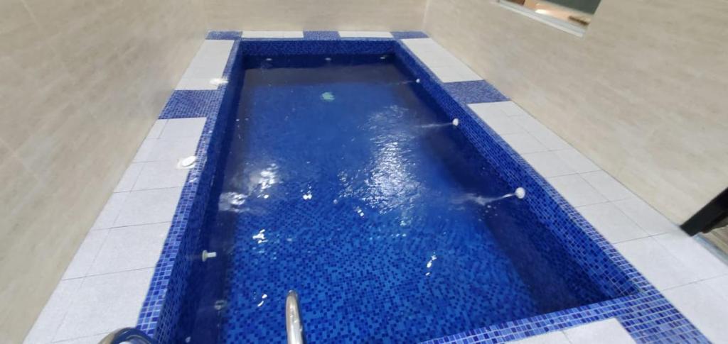 una piscina con azulejos azules en el suelo en شاليهات توليب ابها, en Al Falt