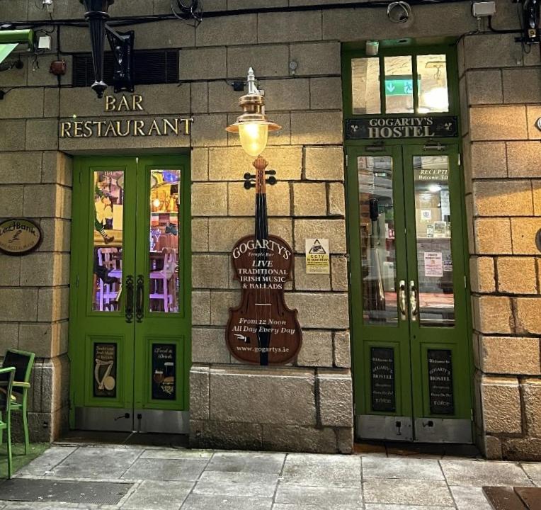 ダブリンにあるGogartys Temple Bar Hostelの緑の扉とギターが付いた建物