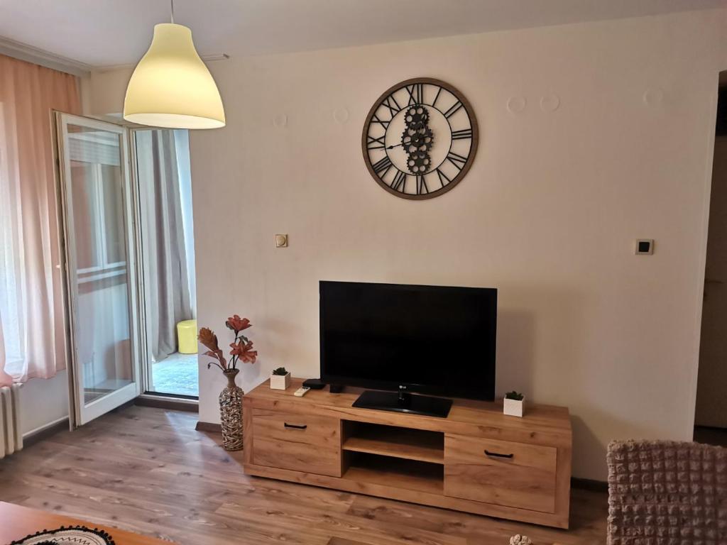 a living room with a tv and a clock on the wall at DiV 3 in Novi Sad