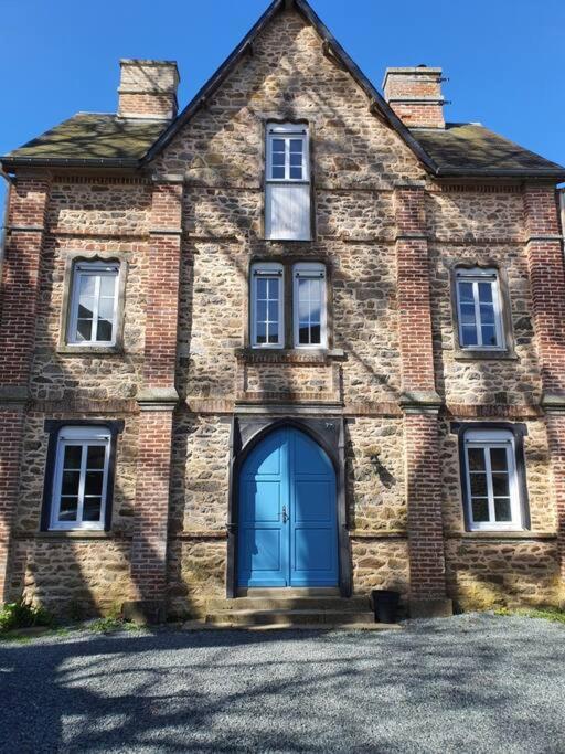 une vieille maison en briques avec une porte bleue dans l'établissement Le Couvent B, à Saint-Jean-Kerdaniel