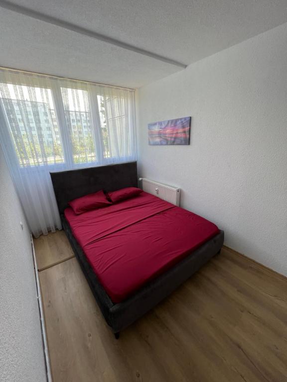 ein Schlafzimmer mit einem großen roten Bett in einem Zimmer in der Unterkunft CozyApartment in Pristina