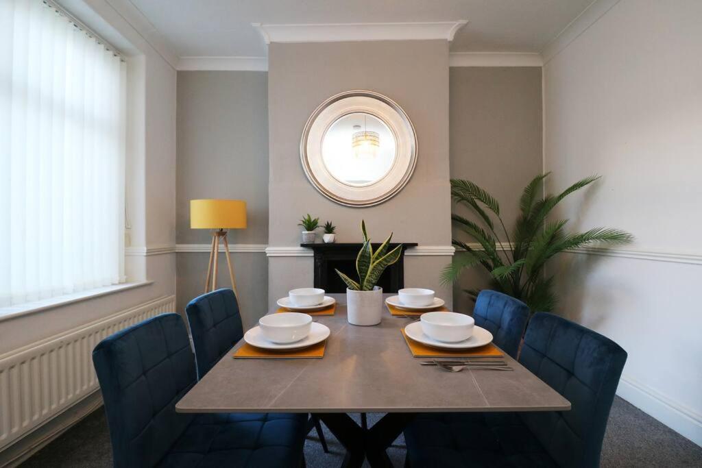 a dining room with a table with chairs and a mirror at 2 Bedroom Characterful House in Lancaster