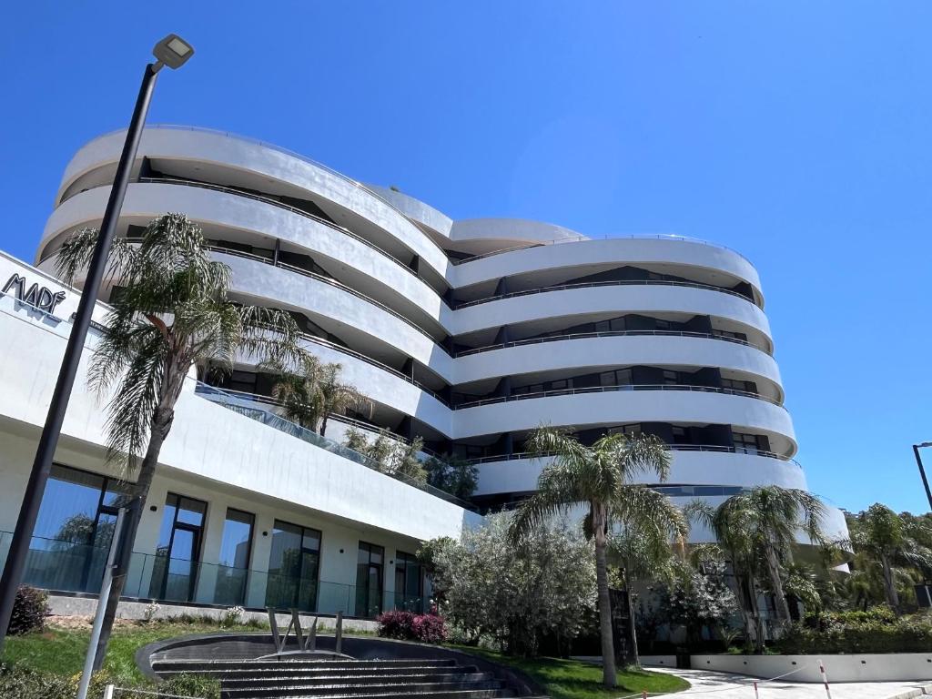 a building with palm trees in front of it at The Touch of the Sea in Durrës