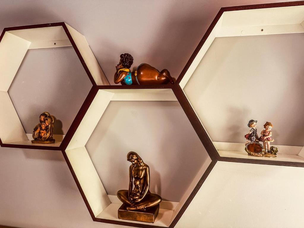a group of figurines sitting on shelves on a wall at Lar Loudge Montanhes in Campos do Jordão