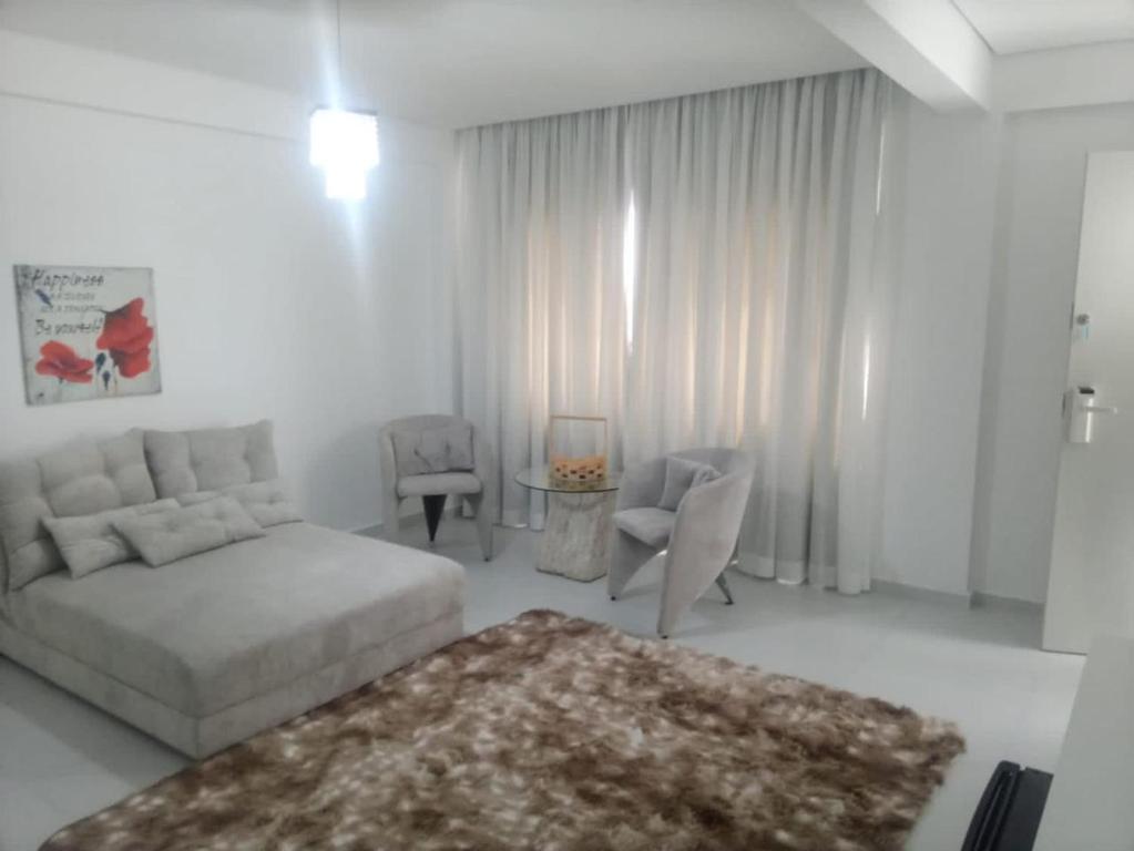 a white living room with a bed and a couch at LEON MARIA HOSPEDAGENS - Smart Flat Hotel e Residence in Mogi das Cruzes
