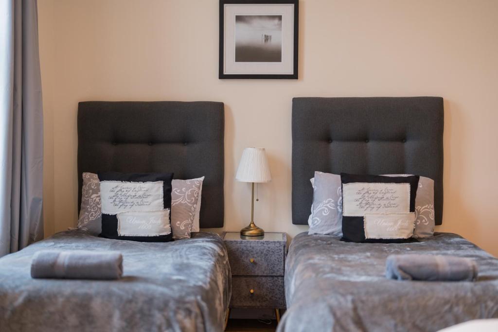 two beds sitting next to each other in a bedroom at Birmingham City Apartment - Spacious & Fully Serviced with Secure Parking in Birmingham
