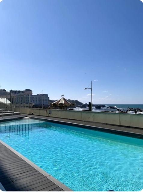 - une grande piscine bleue au-dessus d'un bâtiment dans l'établissement Victoria Surf studio d'exception, à Biarritz