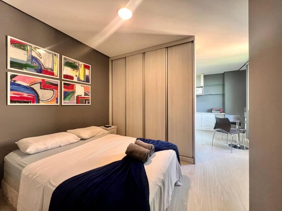 a bedroom with a bed and a room with a desk at BH com Vista Imbatível! in Belo Horizonte