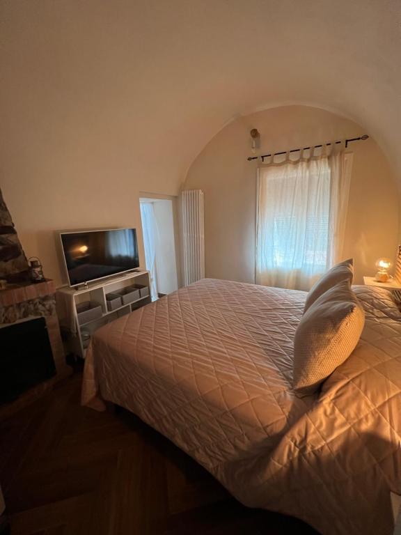 a bedroom with a bed and a flat screen tv at MeiMà Apartment Hanbury’s Gardens in Mortola Inferiore