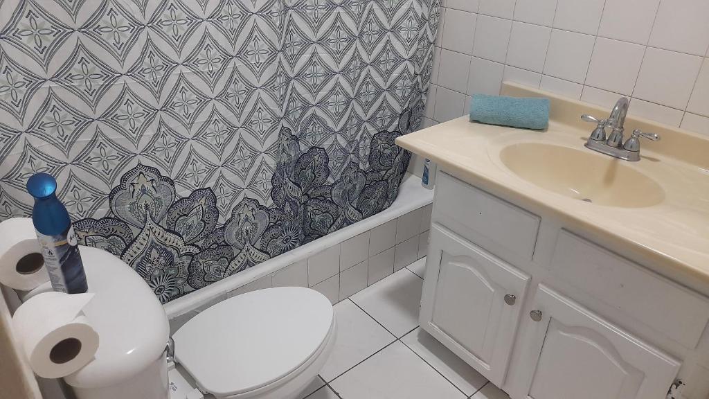 a bathroom with a toilet and a sink and a shower curtain at Kgn6 in Kingston