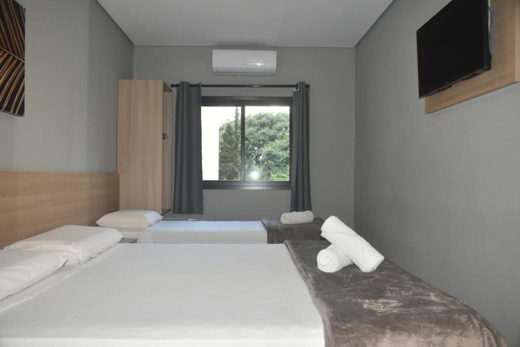 una camera da letto con due letti e una finestra di Unity Hotel - Paulista - SP a San Paolo