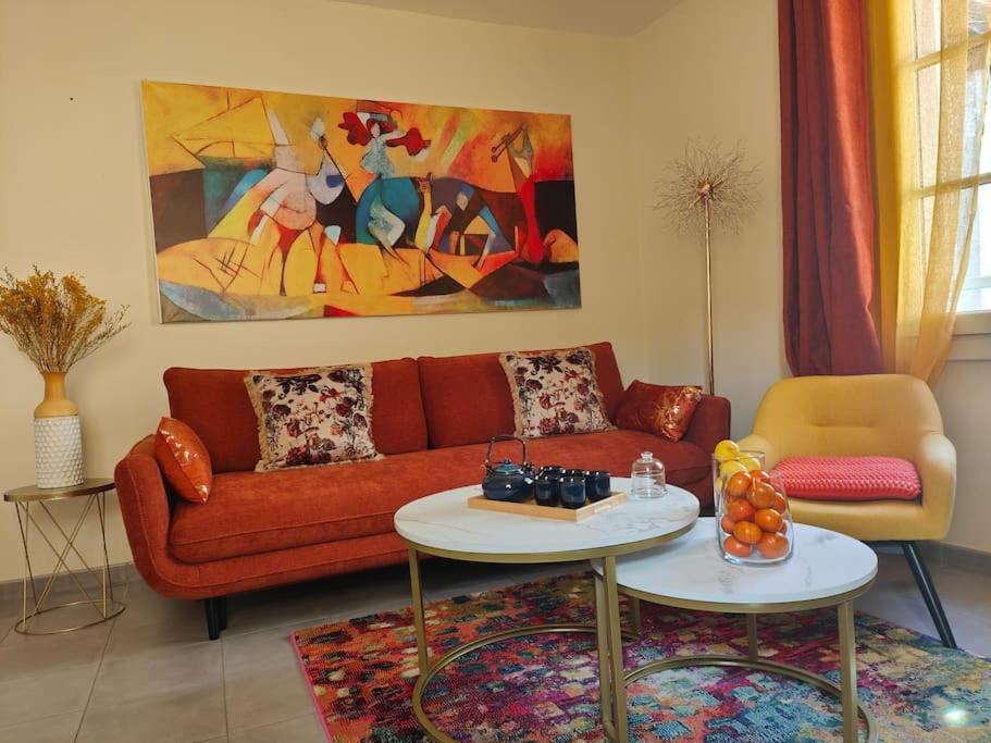 a living room with a red couch and a painting at T2 54m² parking Cœur de Chartres in Chartres