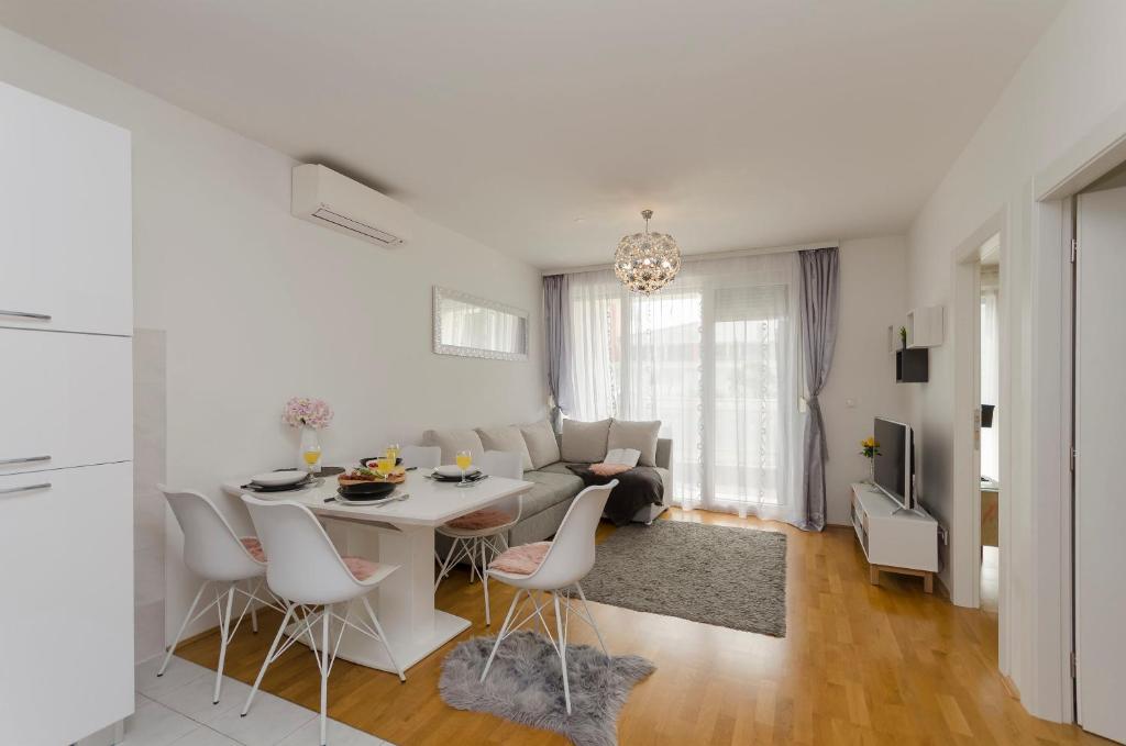 - un salon blanc avec une table et des chaises dans l'établissement Apartment L&I, à Šibenik