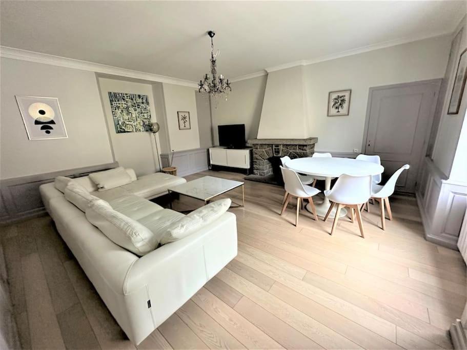 een woonkamer met een witte bank en een tafel bij Maison centre historique in Bayeux
