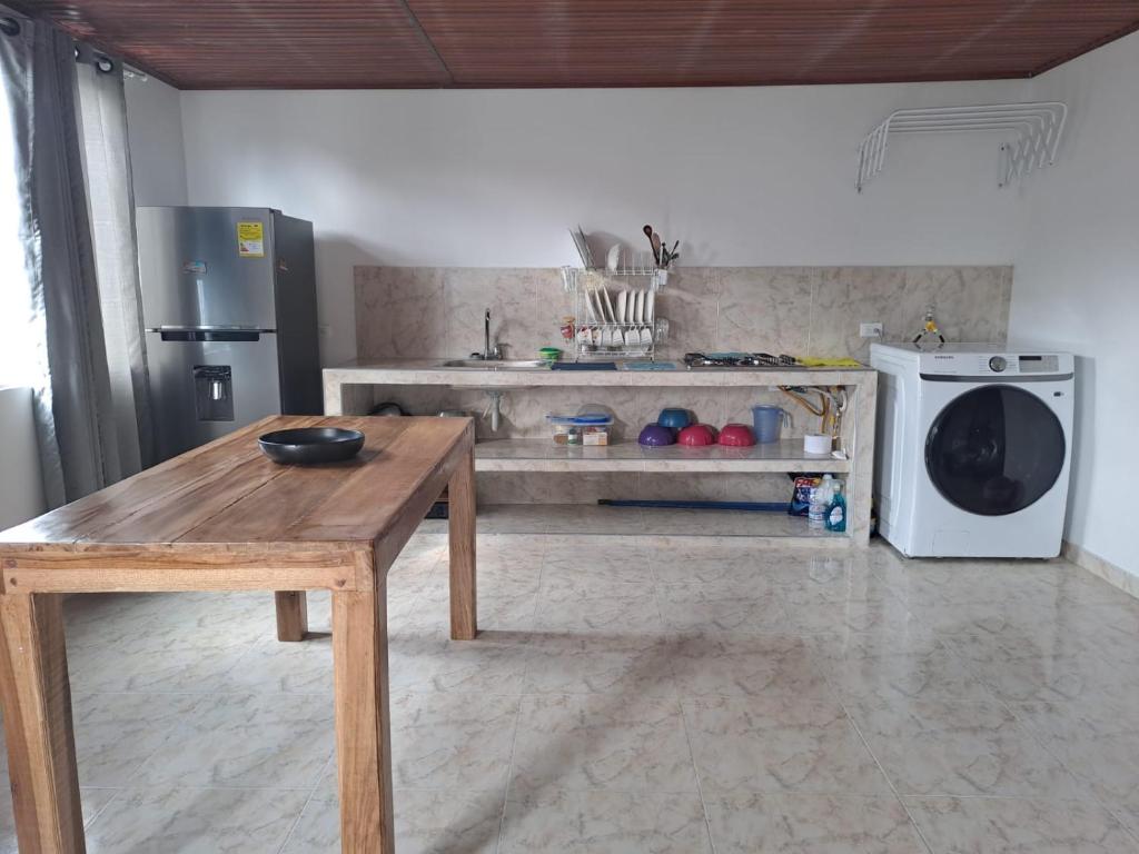una cucina con tavolo in legno e forno a microonde di La Piedra Pintada de los Muiscas a Ibagué