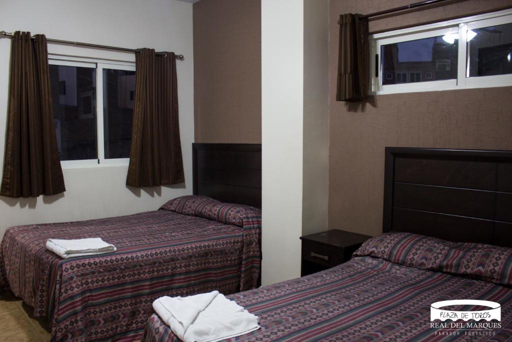 Cette chambre comprend 2 lits et une fenêtre. dans l'établissement Real Plaza de Toros, à San Juan de los Lagos