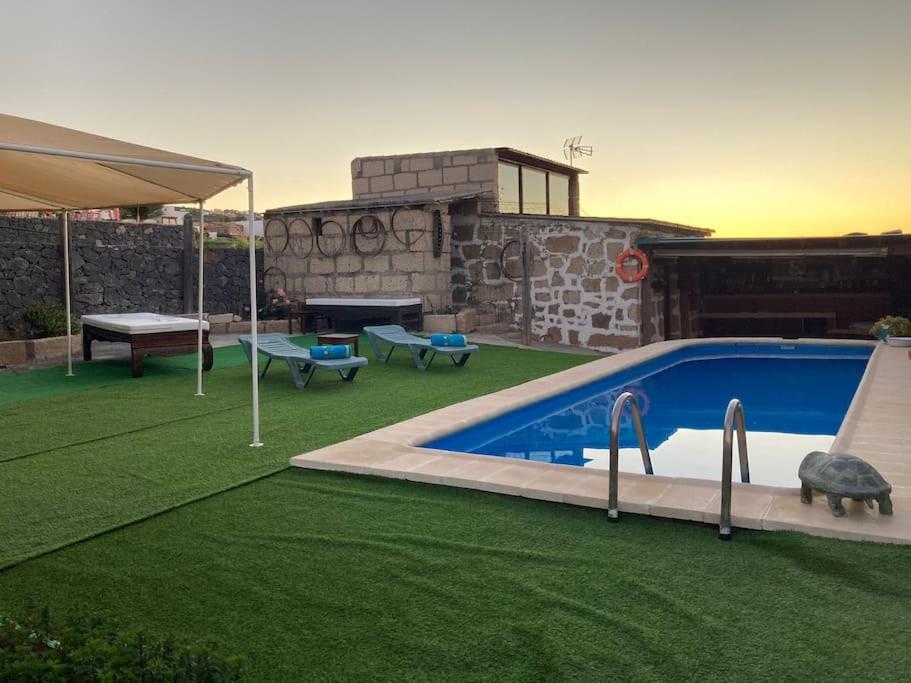 een achtertuin met een zwembad en groen gras bij Casa Rural Tamaide in San Miguel de Abona