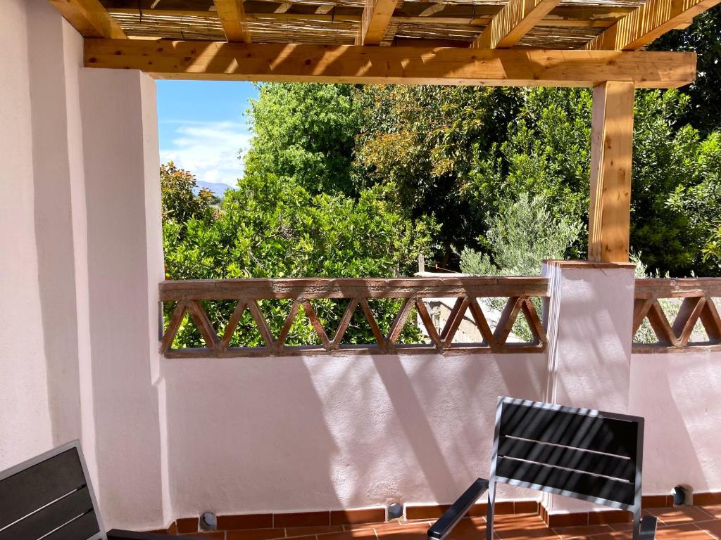 une terrasse avec une pergola en bois et une chaise dans l'établissement L57 - Habitaciones en Órgiva, à Órgiva