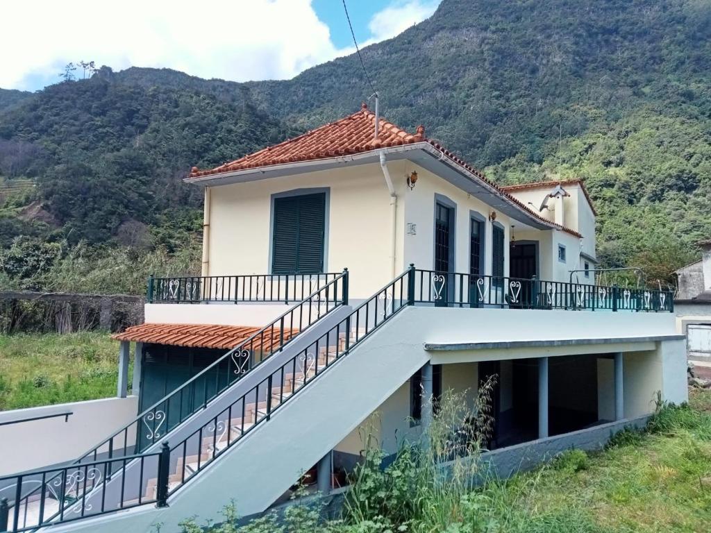 a house with a staircase in front of a mountain at Boaventura Hikers Comfort in Boaventura